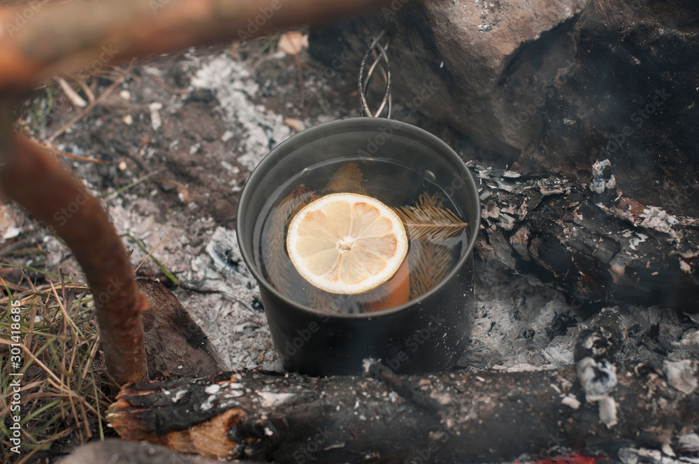 Aromatic and hot herbal tea  on campfire	