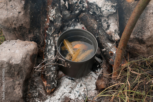 Aromatic and hot herbal tea on campfire 