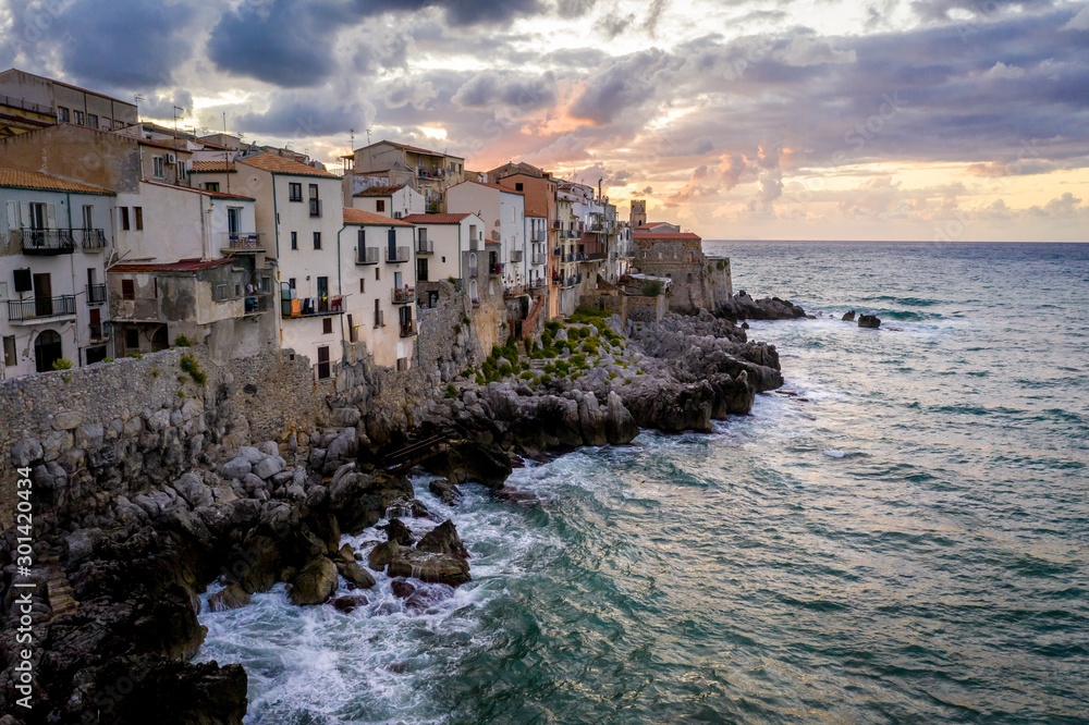 aerial view with the city lights and sunset sky . Italy, Tyrrhenian SeaView of the coastal houses of Cefalu from the Tyrrhenian Sea at sunset, Sicily, Italy