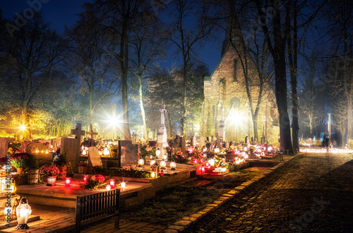 Foto Burning candles on graves during All Saints Day