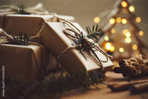 Christmas gifts on wooden table with lights in background photo