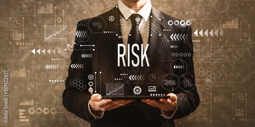 Risk with businessman holding a tablet computer on a dark vintage background photo