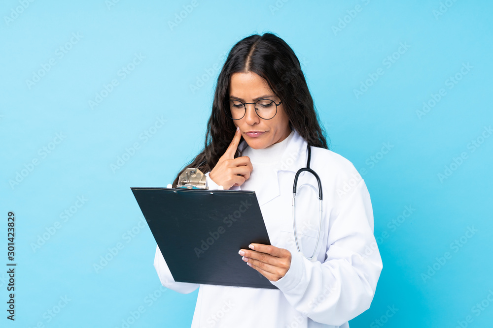 Young doctor woman over isolated blue background Young doctor woman over isolated blue background