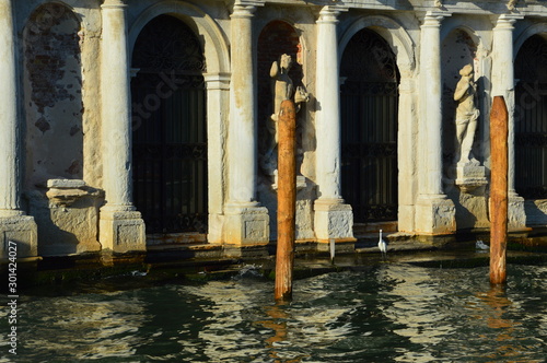 Venice  Italy . June 2019. The facade of a medieval building  on the steps of which a heron lives.