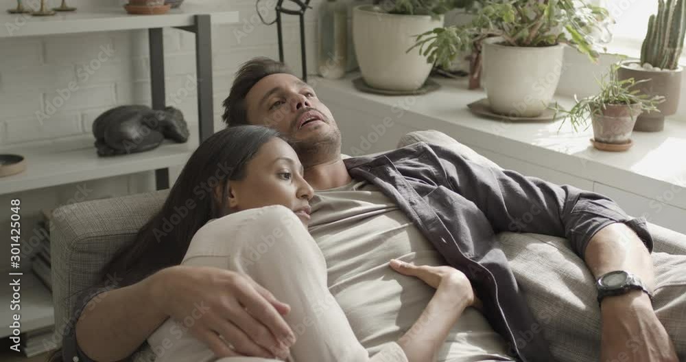 Young adult couple relaxing at home on sofa Young adult couple relaxing at home on sofa