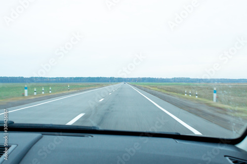 view of the road from the window of a moving car.