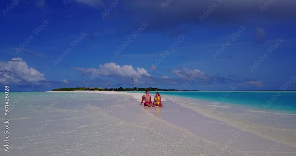 Young Sweet Couple Enjoying the Clean Crystal Water and Getting Tan with Cloudy Blue Sky at the Background in Cuba- Steady Distance shot Young Sweet Couple Enjoying the Clean Crystal Water and Getting Tan with Cloudy Blue Sky at the Background in Cuba- Steady Distance shot