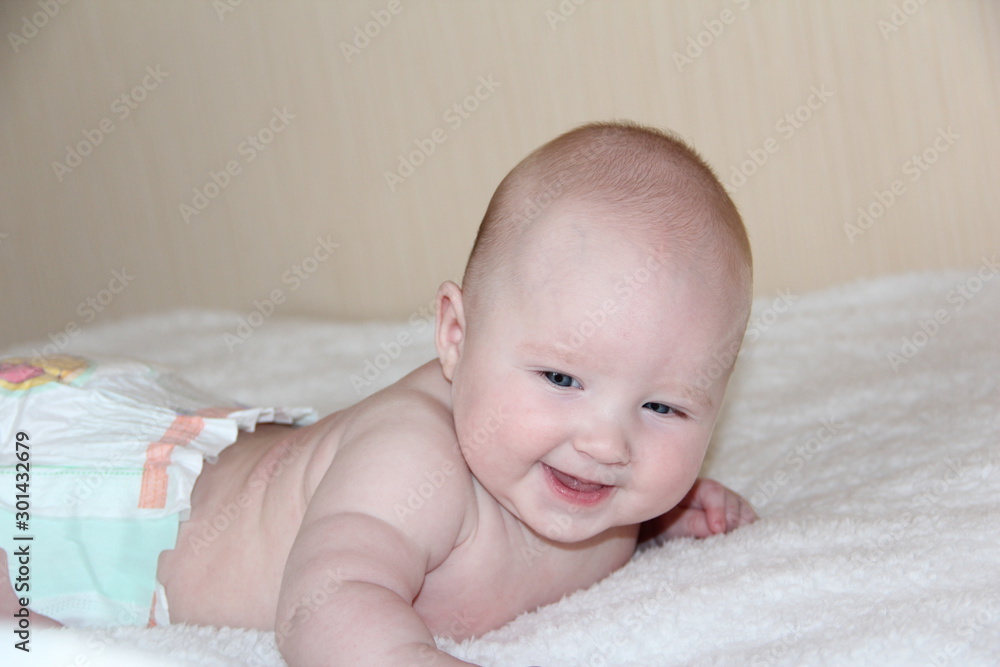 a small child lies on his tummy a small child lies on his tummy