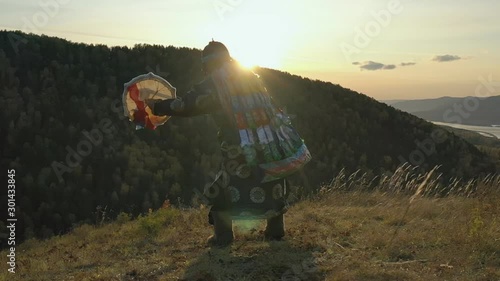 Ritual traditional dance with tambourine Siberian shaman at sunset.