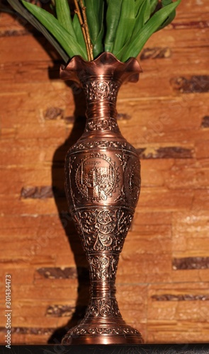 copper vase with patterns on a background of stone photo