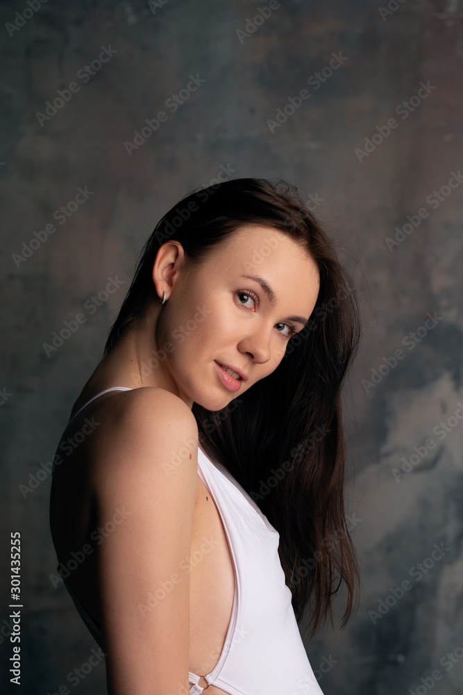 Portrait of smiling brunette girl in white bodysuit Portrait of smiling brunette girl in white bodysuit