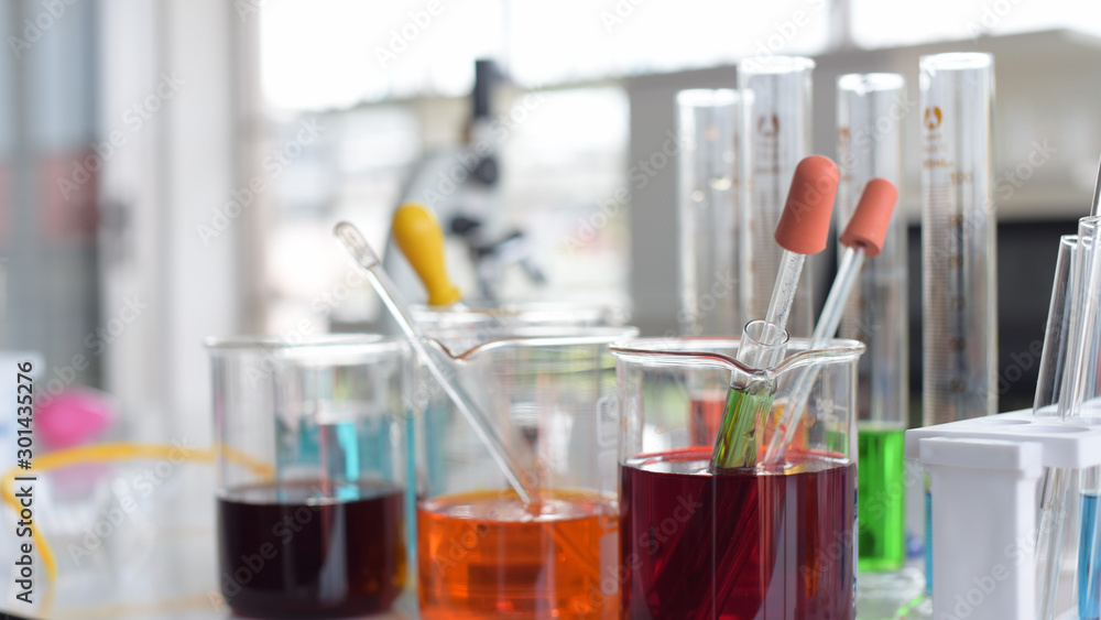 glass test tubes and flasks with colorful liquid on blue background with molecular structure glass test tubes and flasks with colorful liquid on blue background with molecular structure