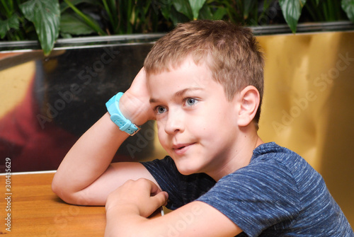 portrait of a cute boy sitting at a table in a cafe