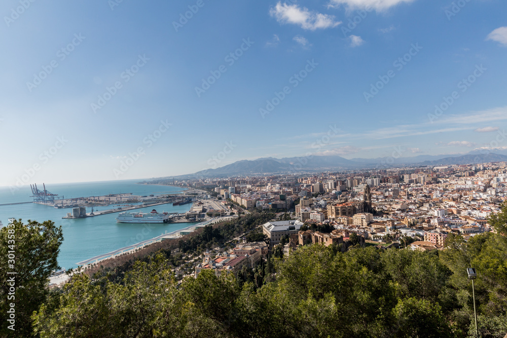 Obraz premium Port, sea, part of the city seen from the Alcazaba of Malaga, sunny day with a blue sky in the province of Malaga, Spain