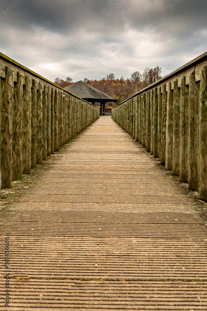 Wooden bridge leading to a gazer in the middle of the Doyards lake, Vielsalm, Belgium