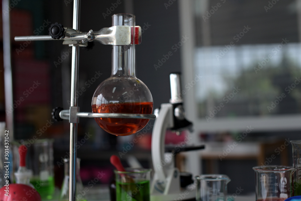 glass test tubes and flasks with colorful liquid on blue background with molecular structure glass test tubes and flasks with colorful liquid on blue background with molecular structure