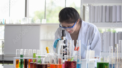 Scientists are working in science labs.Close-up of a scientistYoung female scientist looking through a microscope in a laboratory doing research