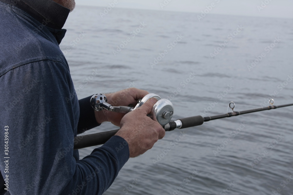 Pescador manejando la caña de pesca Stock Photo | Adobe Stock