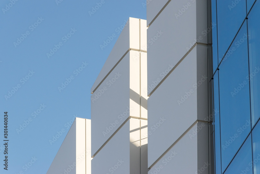 Geometric colored building facade elements with planes, lines and corners with light flare and reflections for an abstract background and texture of white, blue, gray colors. Place for text Geometric colored building facade elements with planes, lines and corners with light flare and reflections for an abstract background and texture of white, blue, gray colors. Place for text