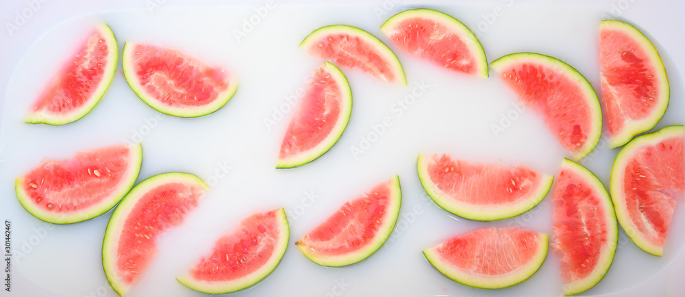Turbid soapy water in bath with slices of watermelon. top view in full frame. The largest berry. spa with milk in the bath for rejuvenation.. Turbid soapy water in bath with slices of watermelon. top view in full frame. The largest berry. spa with milk in the bath for rejuvenation..