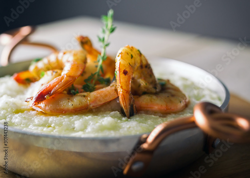 Shrimp and grits in a copper handled dish.  Copy space. 