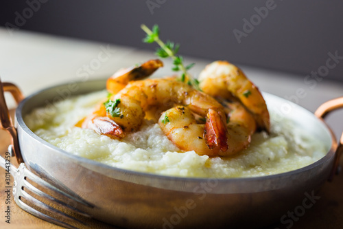 Shrimp and grits in a copper handled dish.  Copy space. 