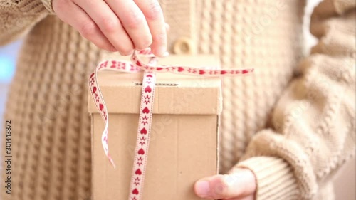 Woman hands unwrapping Christmas present