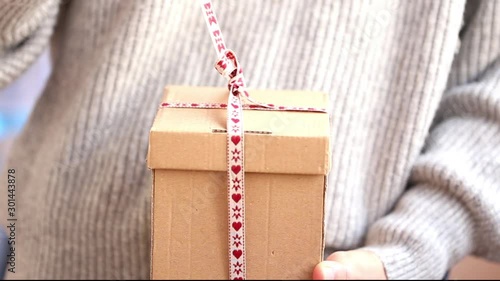 Woman hands unwrapping Christmas present