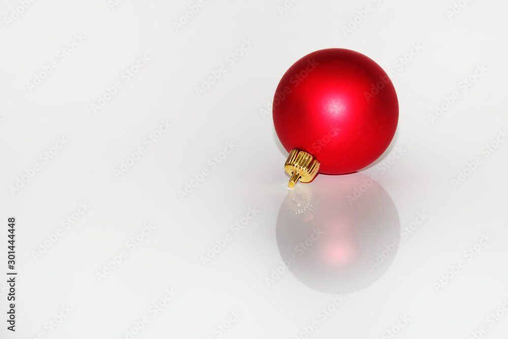 Red christmas ball reflecting on white background Red christmas ball reflecting on white background