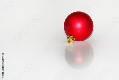 Red christmas ball reflecting on white background