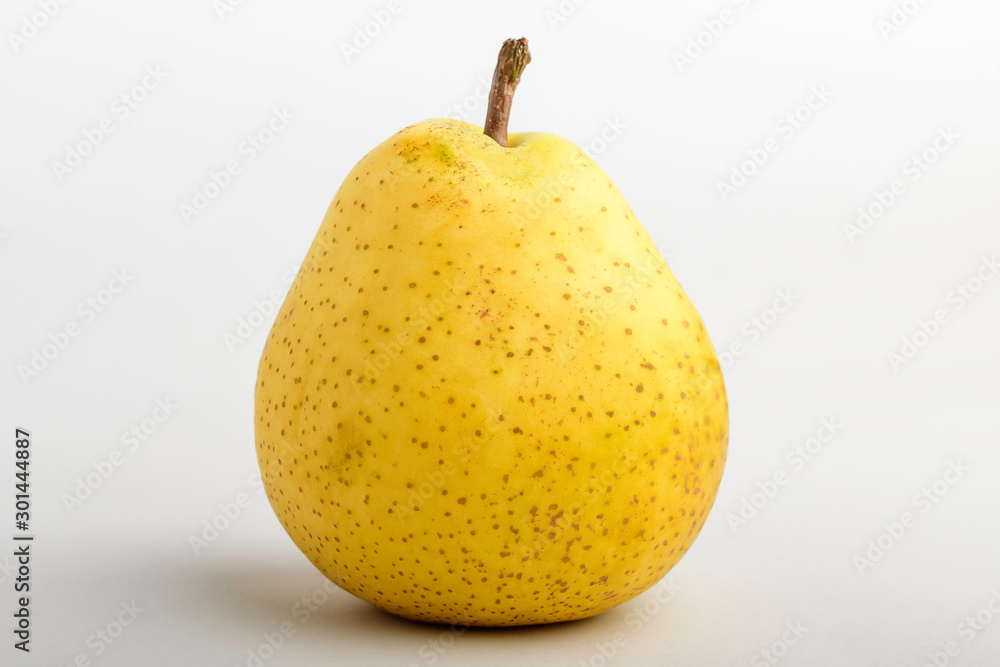 One fresh organic ripe yellow pear on table, isolated on white background, side view with soft focus of tasty healthy food