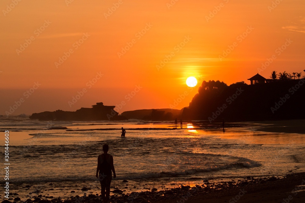 Fototapeta premium silhouette of woman on beach at sunset