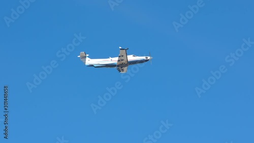 Generic Turboprop Private Airplane Flying in a Blue Sky after Taking Off on a Sunny Day photo