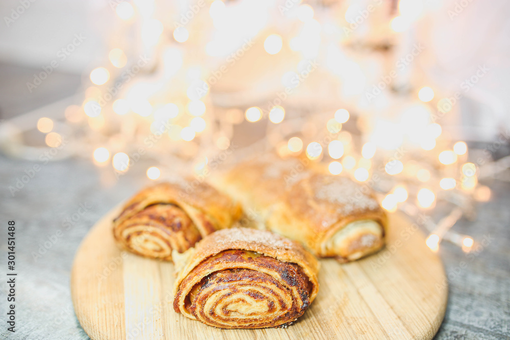 baked christmas strudel with apples on a background of lights. baked christmas strudel with apples on a background of lights.