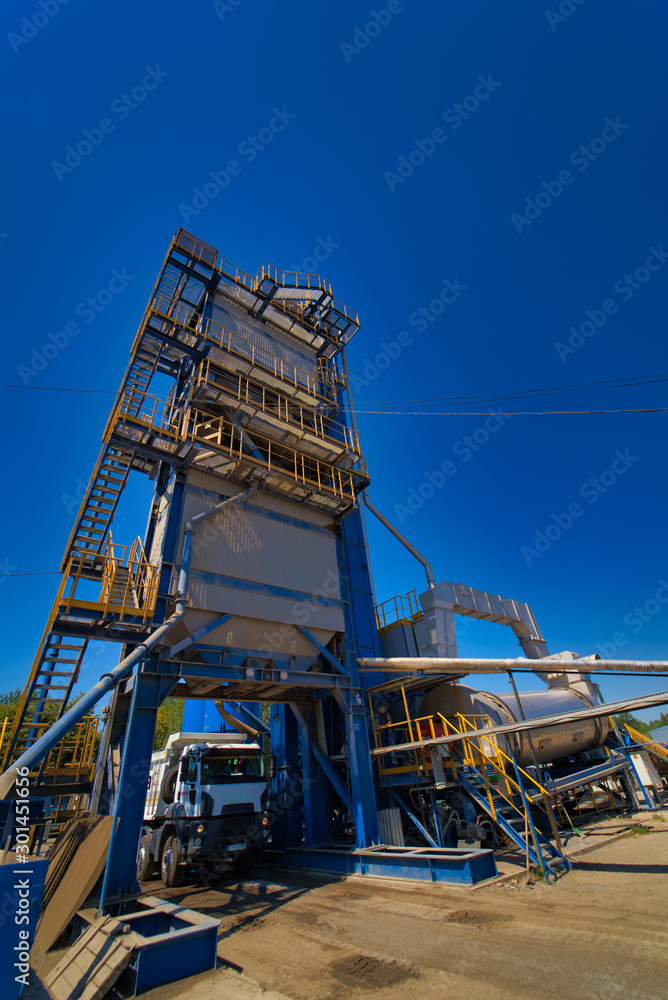 Factory for asphalt production on blue sky background. Selective focus. Factory for asphalt production on blue sky background. Selective focus.