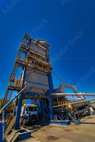 Factory for asphalt production on blue sky background. Selective focus.