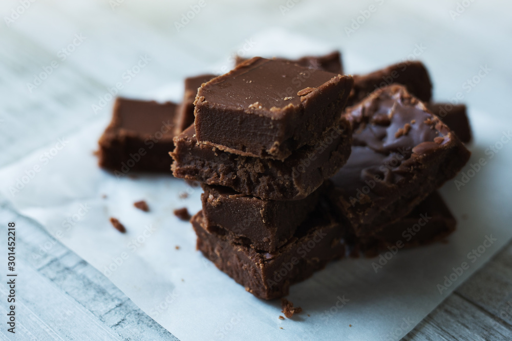 Stack of fudge squares on parchment paper. Stack of fudge squares on parchment paper.