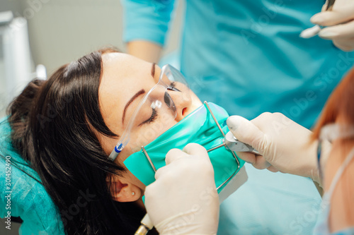 Beautiful woman patient having dental treatment at dentist s office. Female visiting stomatology. Oral care.