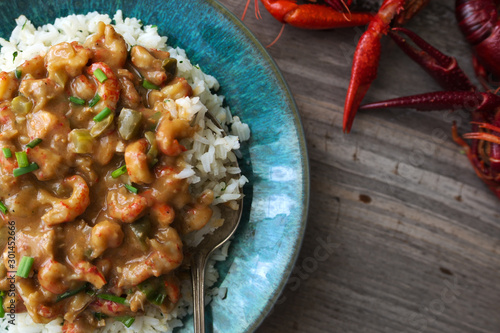 Φωτογραφία Crawfish etouffee over rice, shown with whole crawfish or crayfish on a rustic table