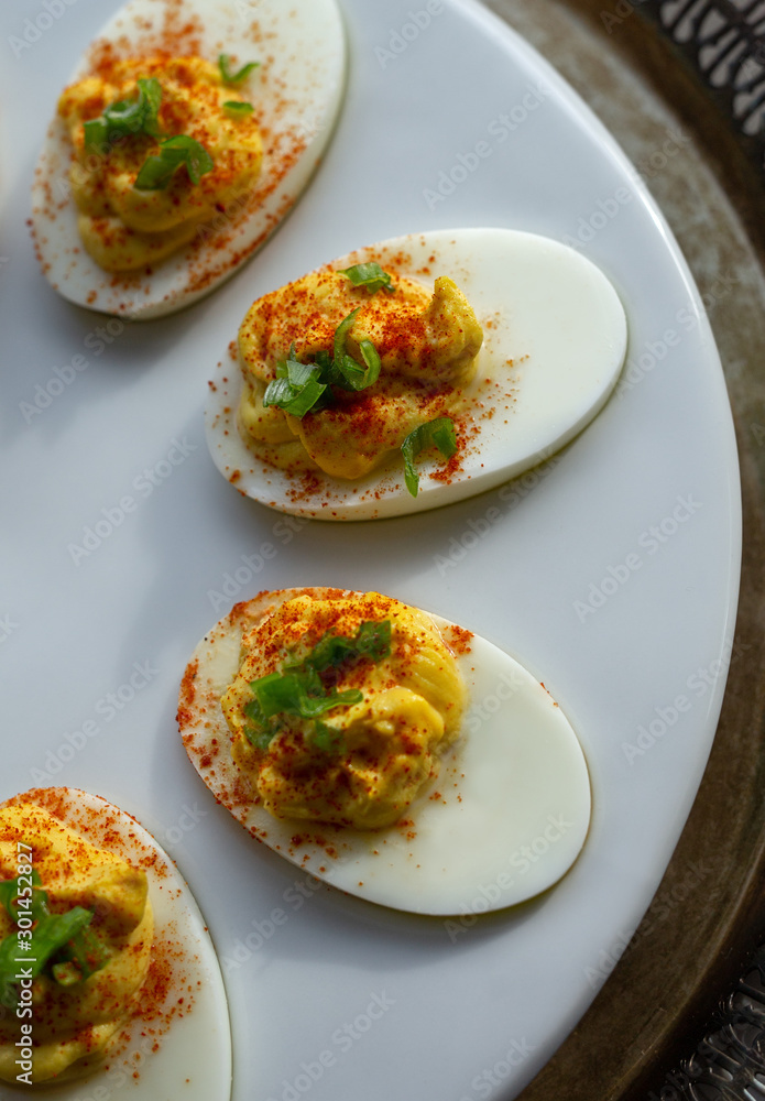 Deviled eggs with paprika on a white serving tray. Deviled eggs with paprika on a white serving tray.