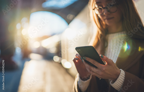 Woman holding in hands mobile phone on platform station. Close up technology smartphone online connect. Girl travel waiting train using gadget cellphone. Wifi internet lifestyle mockup