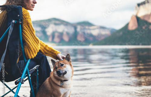 tourist traveler girl relax together friends dog on background mountain landscape,  woman hugging pet rest on lake shore nature trip © A_B_C