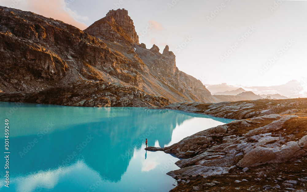 Adventurous man standing on cliff overlooking beautiful Swiss Rockies and Wildsee Lake during a vibrant Autumn sunset. Taken in the Swiss Alps, Switzerland, Europe - obrazy, fototapety, plakaty 