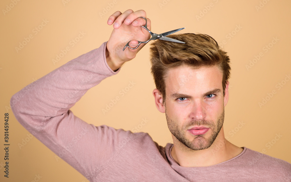 Obraz premium Personal stylist. Bearded man hold scissors. Modern barbershop. Hipster with tool. Designing haircut. Facial care. Cut bangs. Fashion and beauty. Fresh hairstyle. Barbershop concept. Barbershop salon