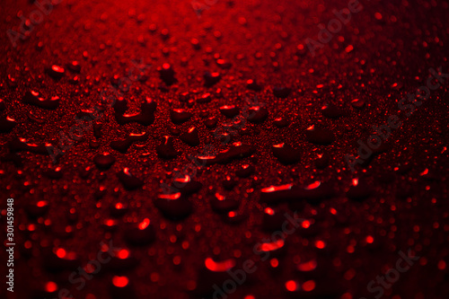 water drops on a plastic red background in the dark