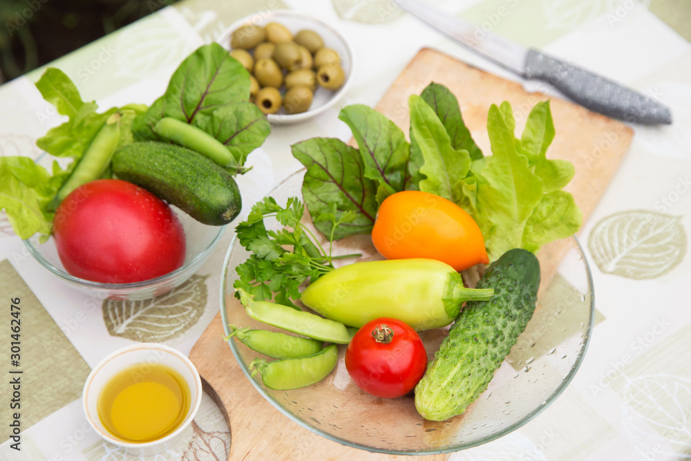 Fresh raw vegetables and greens on plate. Ingredients for cooking vegetarian, diet healthy food Fresh raw vegetables and greens on plate. Ingredients for cooking vegetarian, diet healthy food