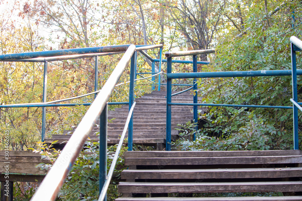 An old staircase of metal and wood on a cliff leading to a sea beach An old staircase of metal and wood on a cliff leading to a sea beach