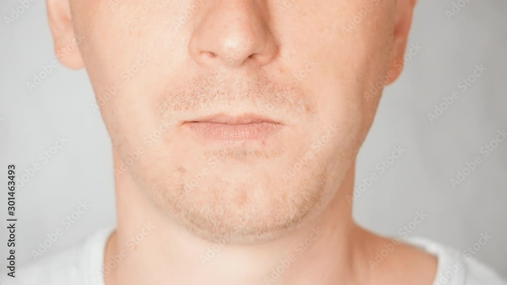 lower face caucasian male eats chocolate bar portrait guy bites and chews lower face caucasian male eats chocolate bar portrait guy bites and chews