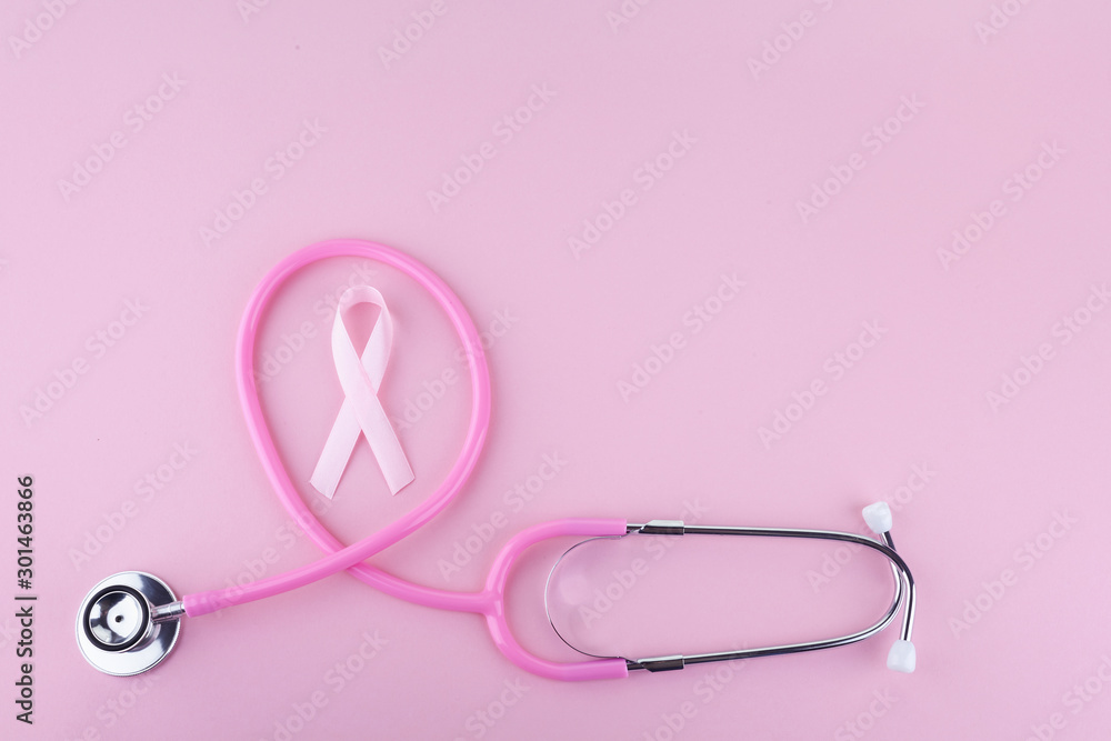 Fototapeta premium Pink ribbon and stethoscope on pink background, Symbol of breast cancer in women, Health care concept