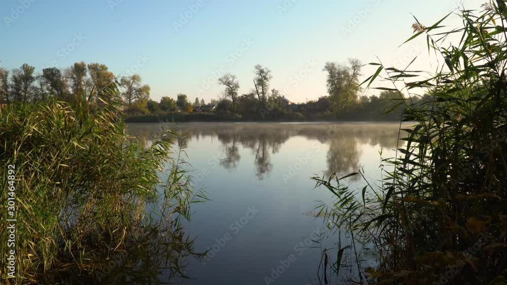 Sunrise on the riverbank. Landscape with reeds on first plan and smoke on the water. Sunrise on the riverbank. Landscape with reeds on first plan and smoke on the water.